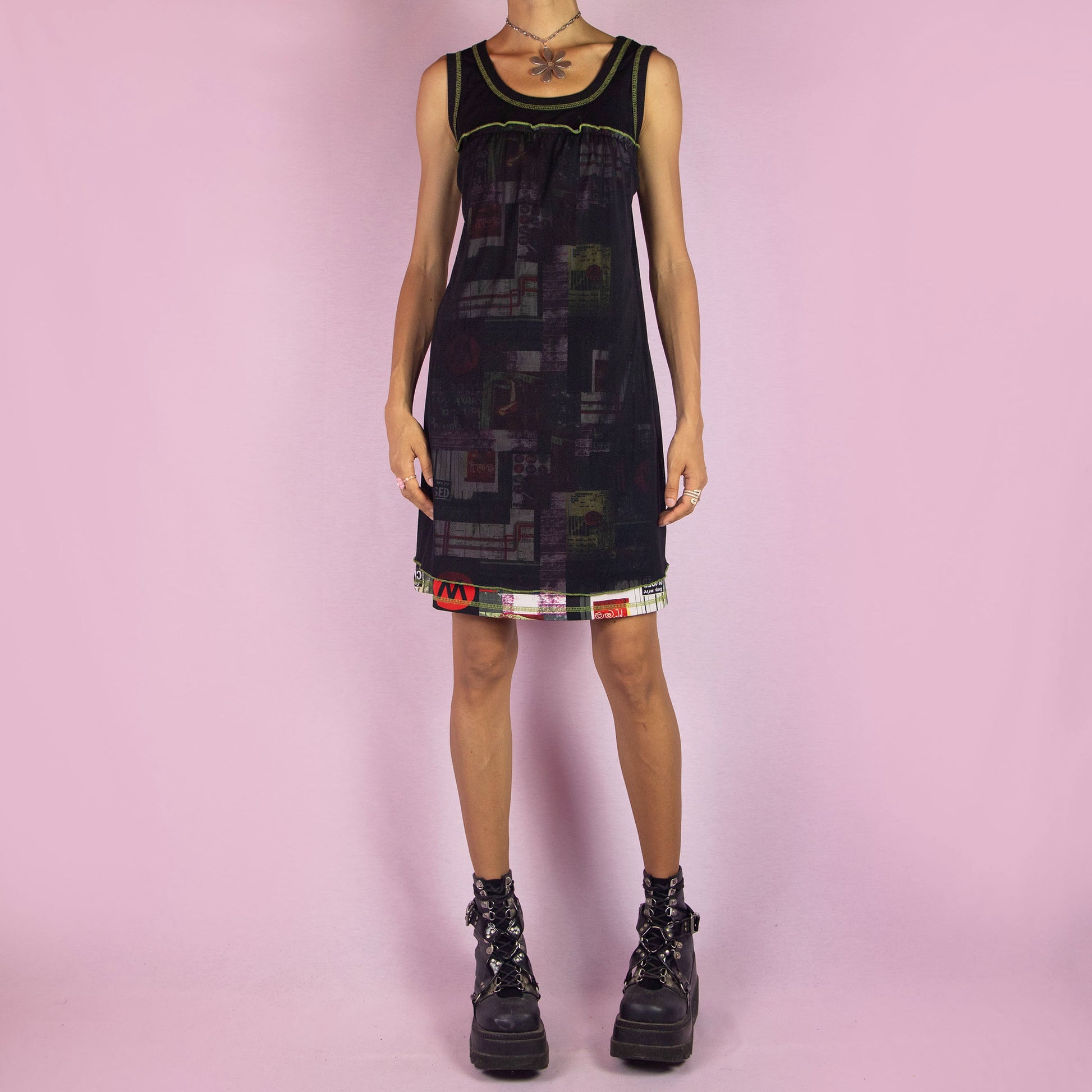 The Y2K Black Sleeveless Mesh Dress is a vintage 2000s mini dress featuring a scoop neckline, relaxed fit, and lightweight mesh fabric. The dress is adorned with abstract prints and neon green stitching along the neckline and hem. Its layered design and playful details make it perfect for casual summer outings.