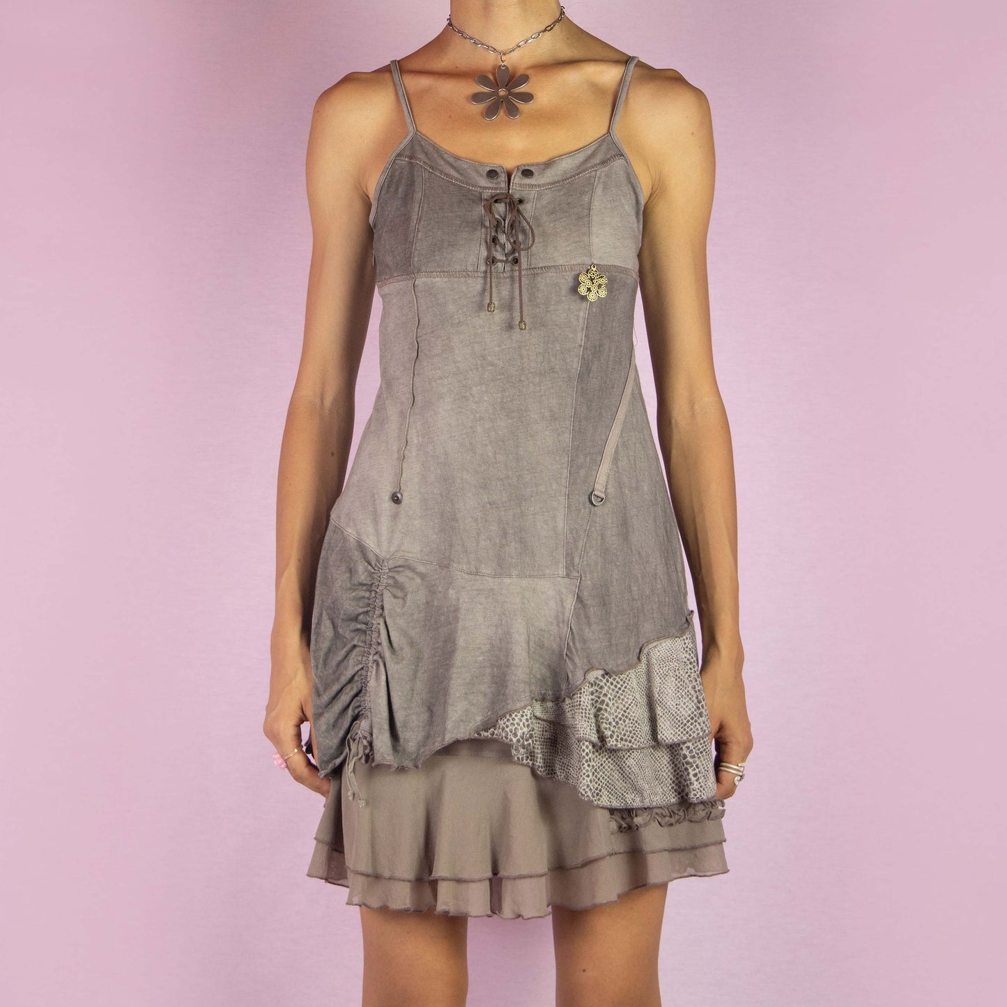 The Y2K Layered Mini Dress is a vintage 2000s piece featuring a lace-up bodice, adjustable spaghetti straps, and a side zipper closure. It has an asymmetrical hemline with layered mesh details, including ruched accents for a romantic touch. The stretchy fabric and whimsical patchwork design make it perfect for casual wear, summer outings, or a dreamy, bohemian-inspired look.