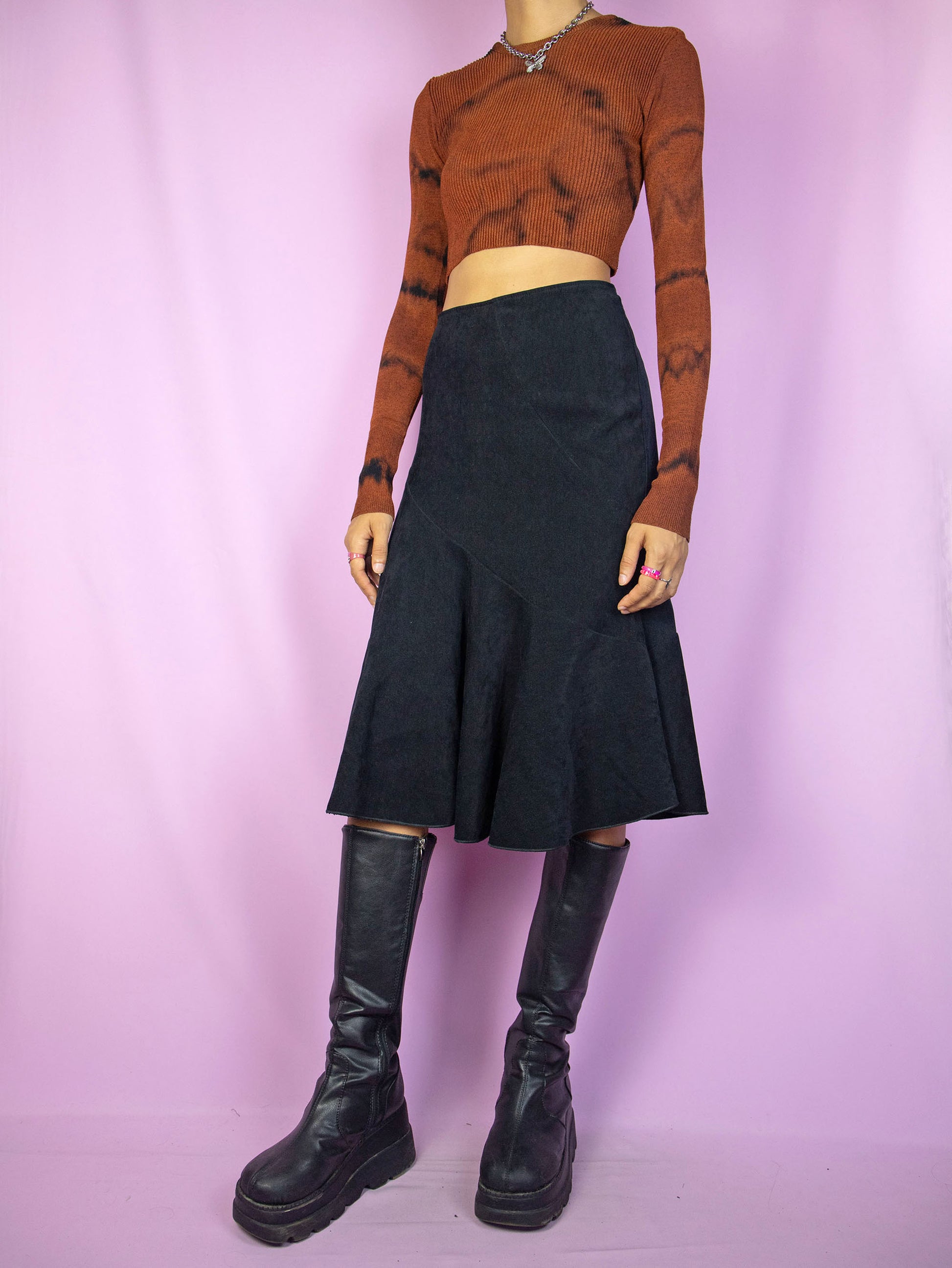 The Vintage 90's Black Trumpet Midi Skirt is a black faux suede skirt with a flared hem and a back zipper closure. A gorgeous and elegant dark fairy goth maxi skirt from the 1990s.