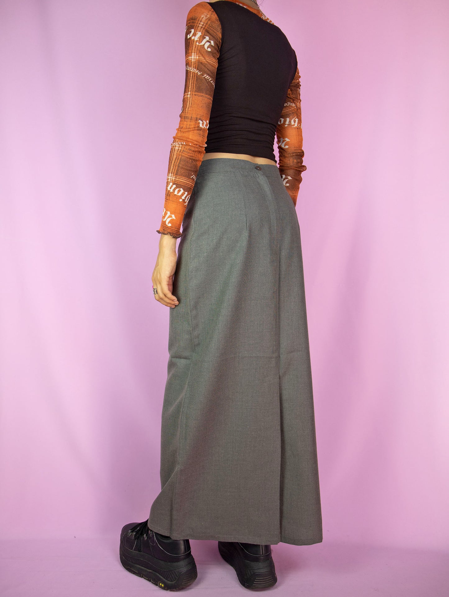 The Vintage 90s Gray Maxi Skirt is a slit-back skirt in gray that ties in the front, featuring a pocket and back zipper closure. Cyber grunge 1990s cargo midi skirt.