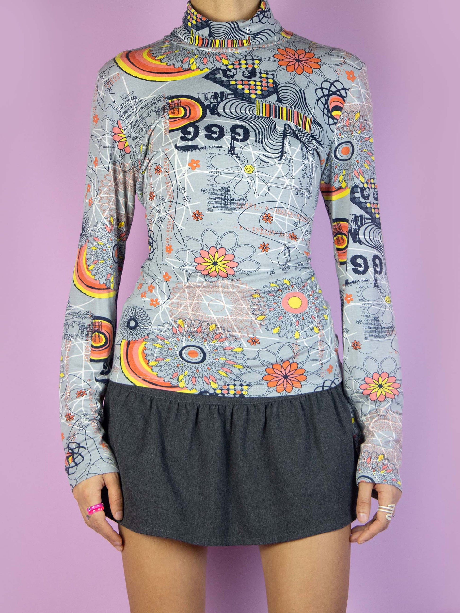 The Y2K Gray Print Turtleneck Top is a vintage 2000s piece featuring a high neck, long sleeves and an abstract eclectic print with colorful geometric patterns and floral designs, perfect for any casual outfit.