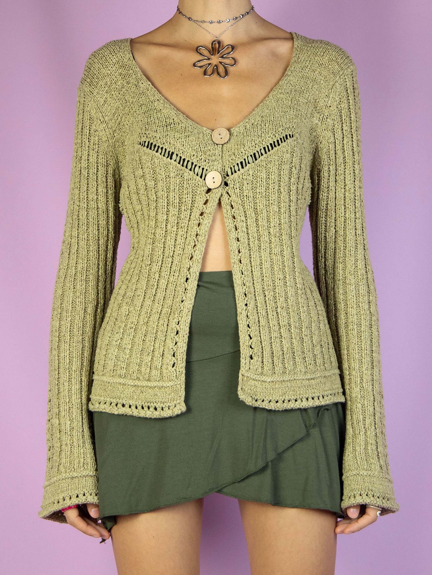 The Y2K Green Two-Button Cardigan is a vintage ribbed cardigan in green-beige with bell sleeves and a two-button closure, featuring a v-neck. Super cute boho fairy grunge 2000s knit sweater.