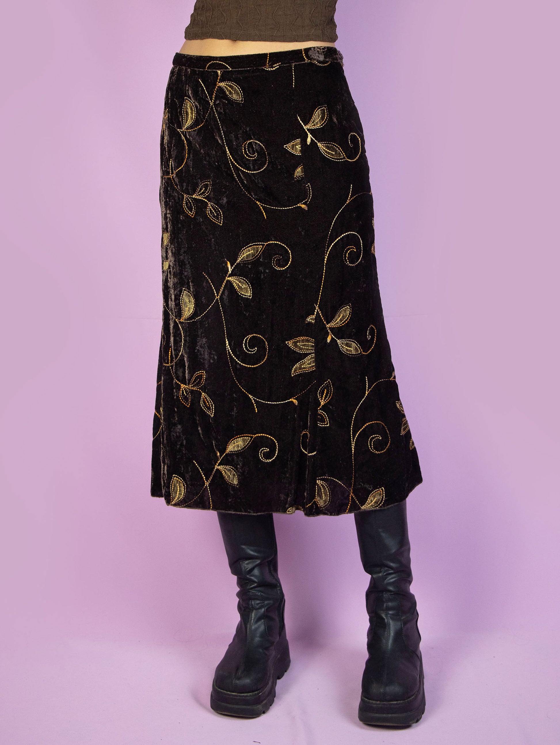 The Vintage 90s Brown Velvet Midi Skirt is a dark brown velvet flared skirt with floral embroidered details and side zipper closure. Gorgeous fairy grunge whimsygoth style 1990s boho skirt.