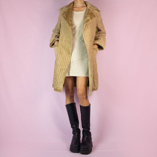 The Y2K Beige Faux Fur Long Coat is a vintage 2000s piece featuring a textured ribbed exterior with a plush faux fur lining throughout. This casual overcoat has a double-breasted button closure, faux fur-trimmed collar, cuffs, and hem, as well as front pockets. Perfect for keeping cozy during casual winter outings.