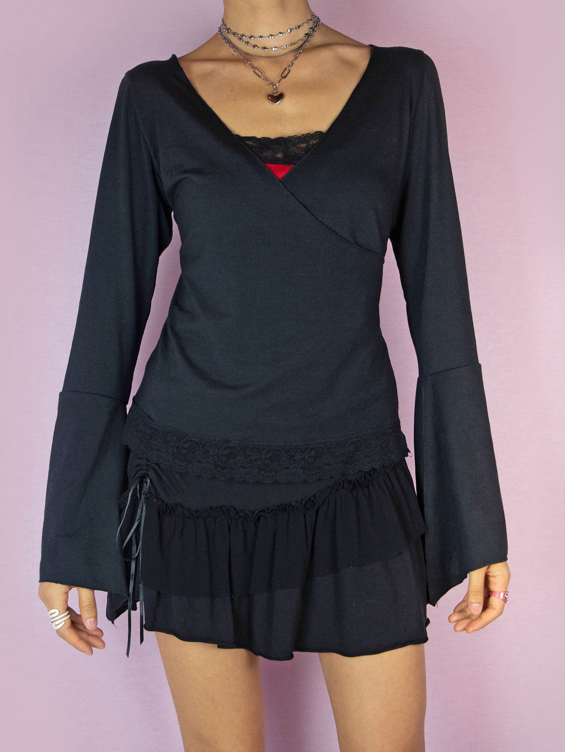 The Y2K Black Bell Sleeve Wrap Top is a stretchy long sleeve vintage 2000s fairy goth inspired shirt with a V-neck and lace details.