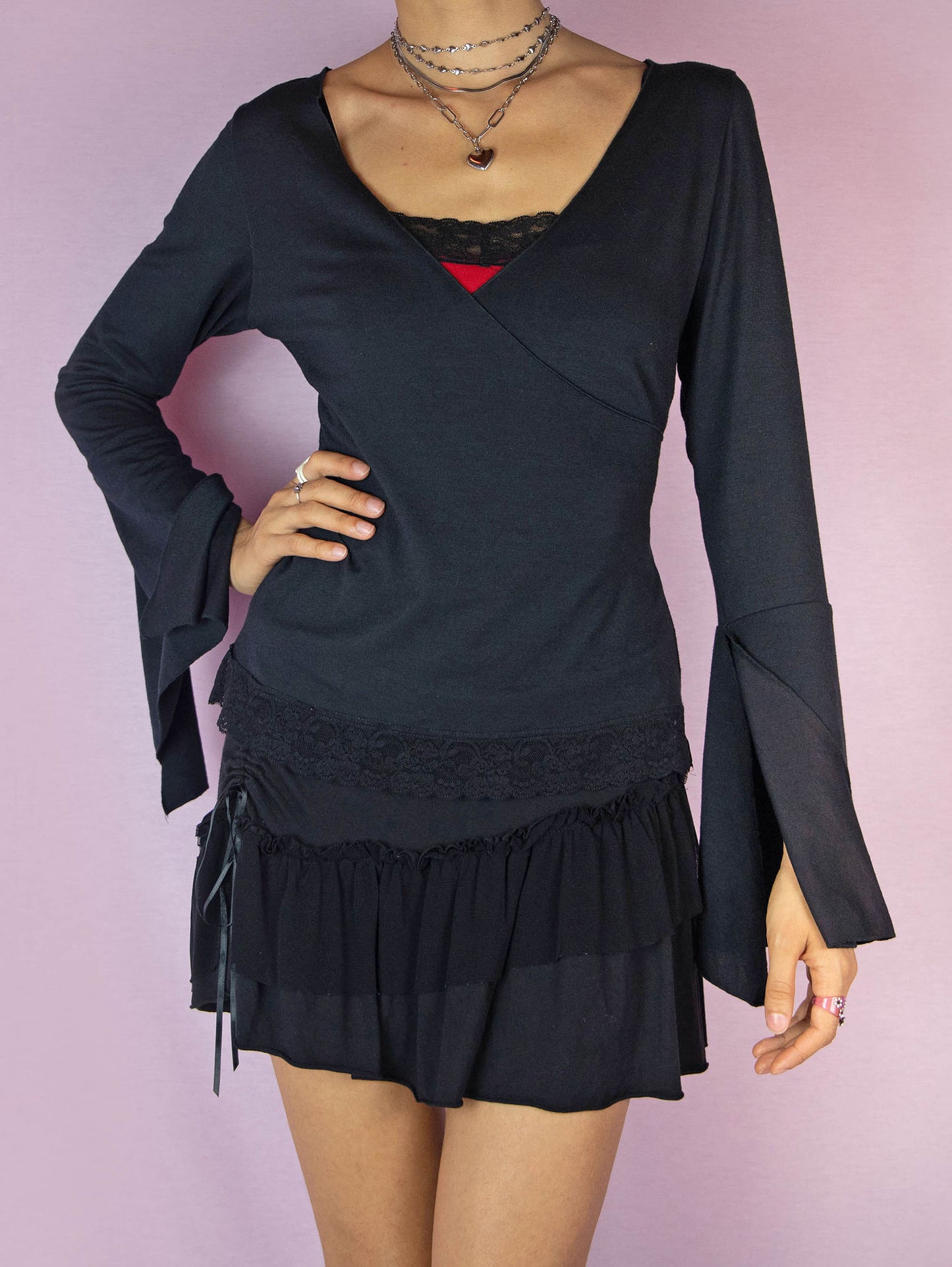 The Y2K Black Bell Sleeve Wrap Top is a stretchy long sleeve vintage 2000s fairy goth inspired shirt with a V-neck and lace details.