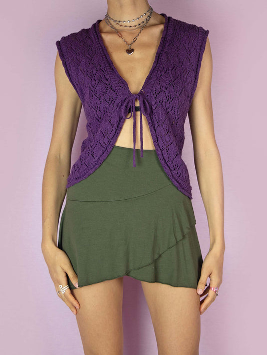The Y2K Knit Tie Bolero Shrug is a vintage 2000s purple sleeveless crochet knit vest cardigan that ties in the front.