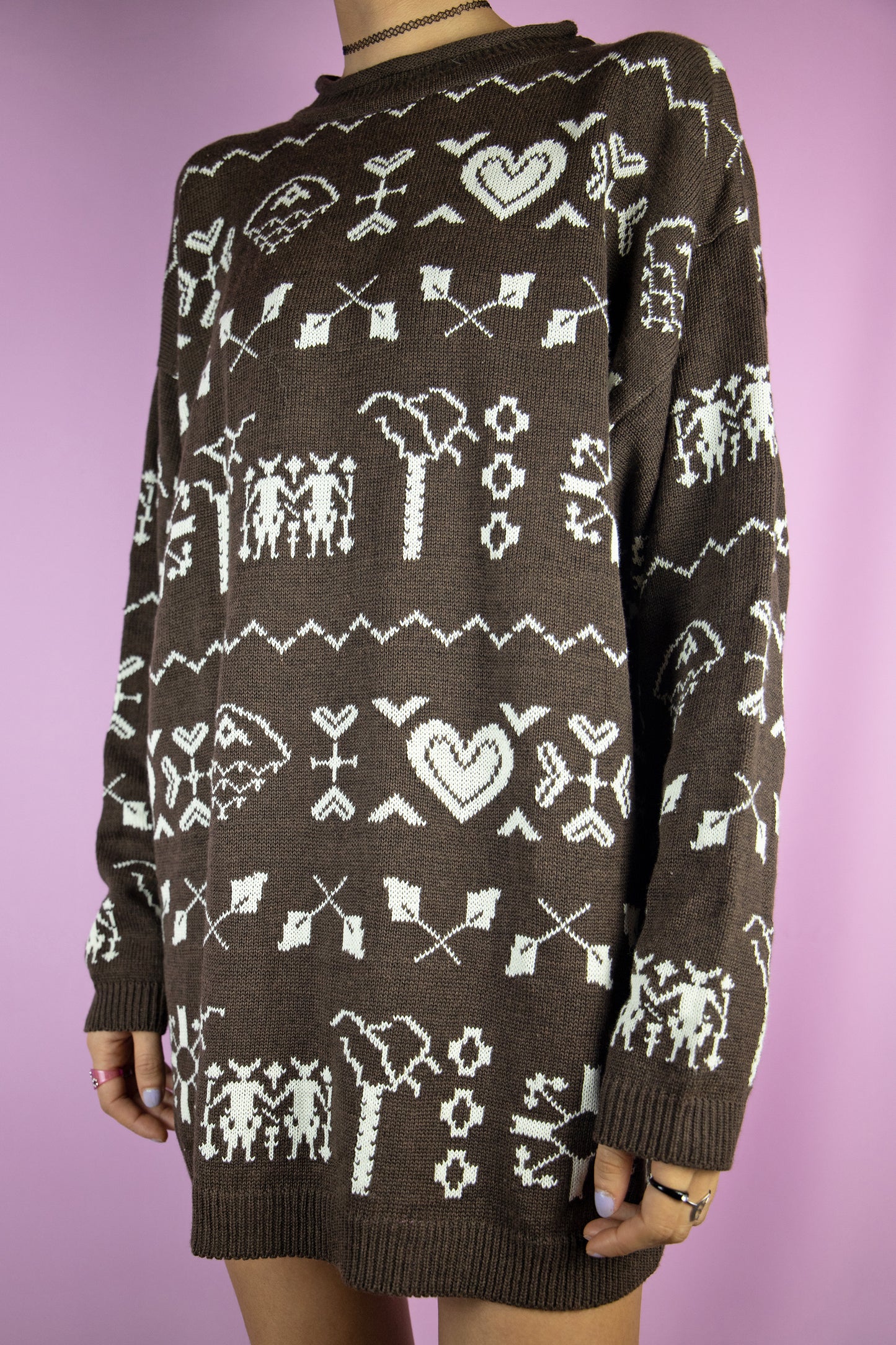 The Vintage 90s Brown Pattern Sweater is a dark brown knit pullover featuring an abstract geometric heart pattern. Perfect for any casual winter outfit.