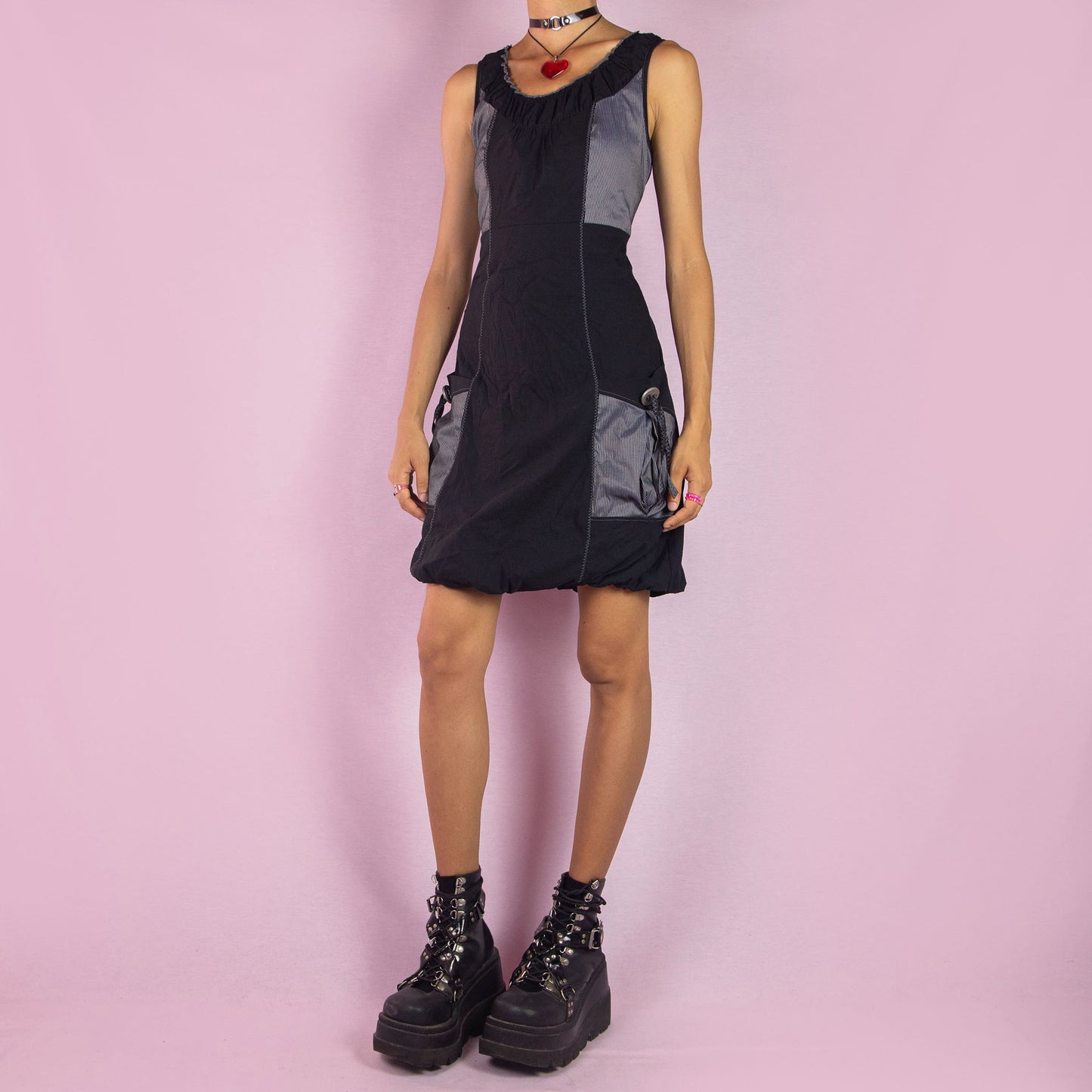 The Y2K Mini Black Bubble Dress is a vintage 2000s piece featuring a sleeveless design and a bubble hemline. Made from a lightweight, stretchy fabric, this dress is accented with contrast side panels and front pockets. Perfect for casual summer outings or party wear.