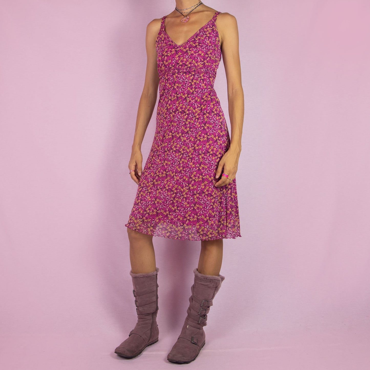 The Y2K Pink Mesh Midi Dress is a vintage 2000s piece featuring a floral print with a semi-sheer mesh overlay. This dress has a flattering V-neckline, and a flowy silhouette, making it perfect for summer outings, beach days, or casual events.