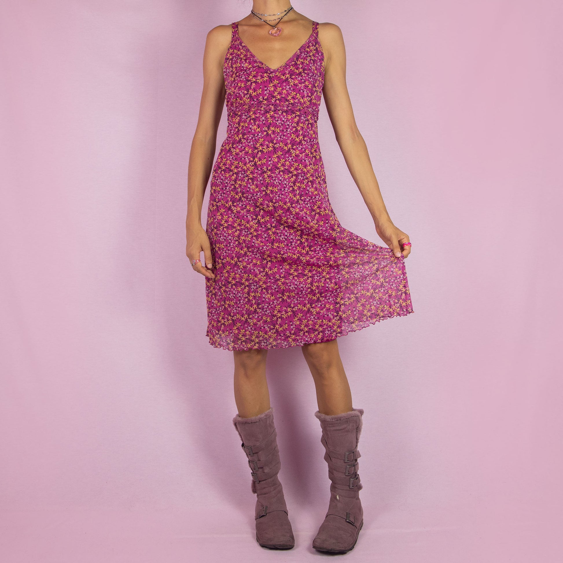 The Y2K Pink Mesh Midi Dress is a vintage 2000s piece featuring a floral print with a semi-sheer mesh overlay. This dress has a flattering V-neckline, and a flowy silhouette, making it perfect for summer outings, beach days, or casual events.