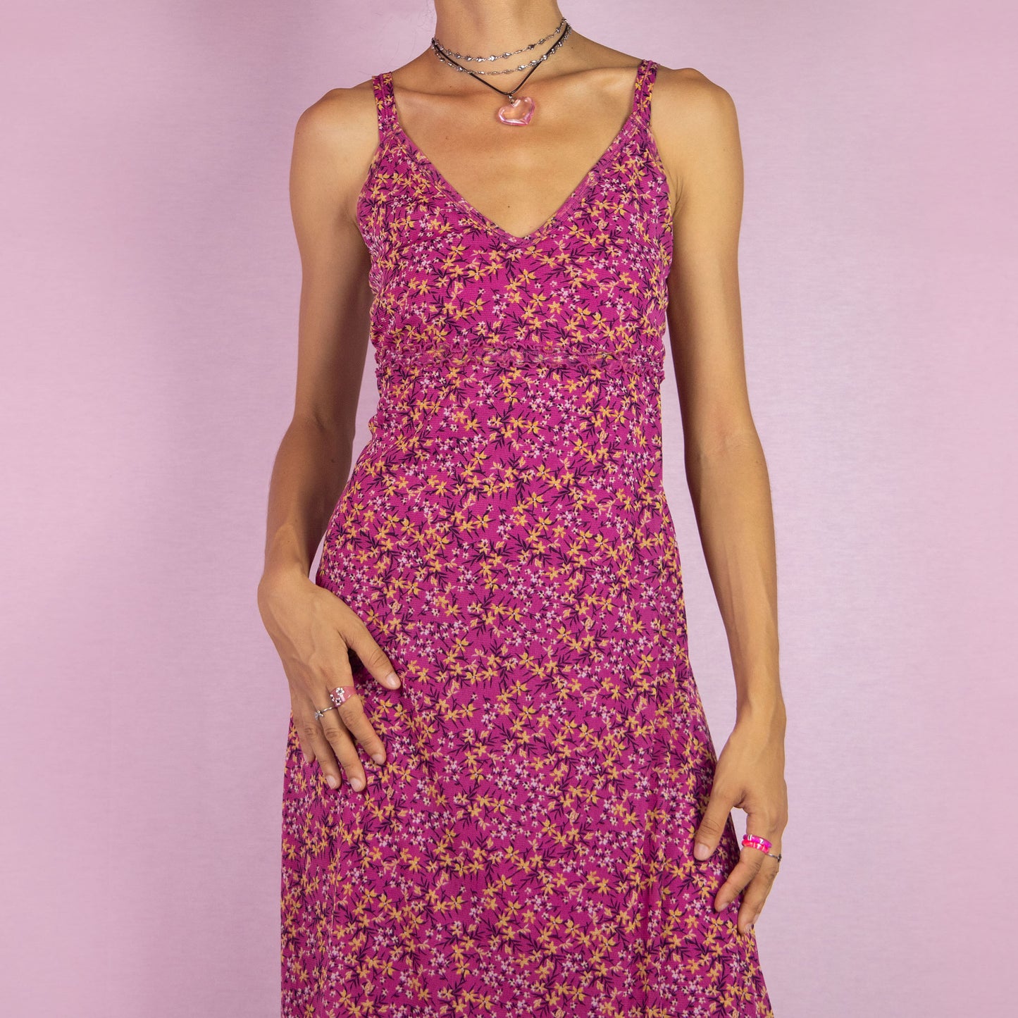 The Y2K Pink Mesh Midi Dress is a vintage 2000s piece featuring a floral print with a semi-sheer mesh overlay. This dress has a flattering V-neckline, and a flowy silhouette, making it perfect for summer outings, beach days, or casual events.