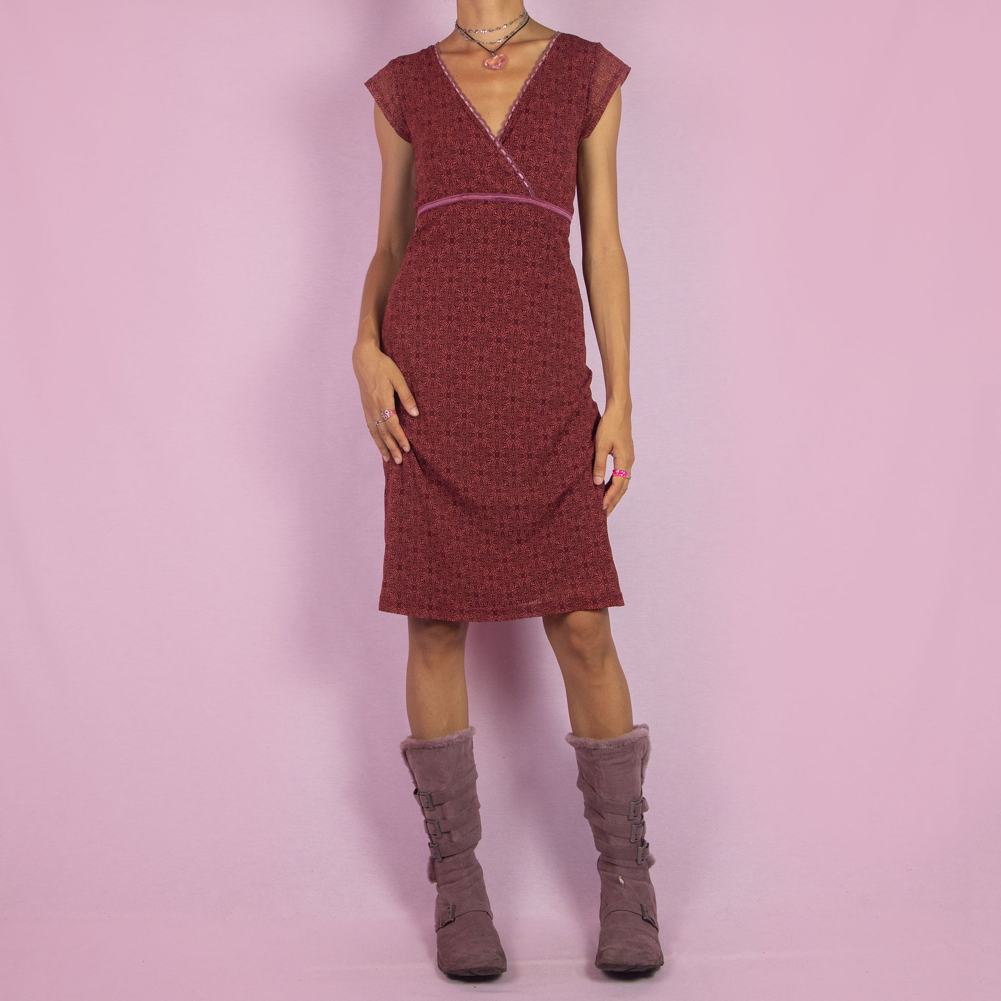 The Y2K Wrap Mesh Midi Dress is a vintage 2000s piece featuring a semi-sheer maroon-red mesh fabric with a geometric pattern. It has a flattering wrap-style V-neckline, cap sleeves, and a fitted silhouette. Perfect for casual summer outings.