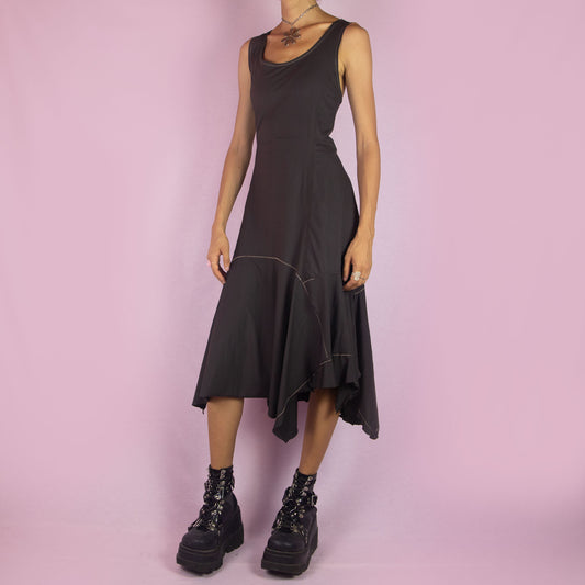 The Y2K Asymmetric Brown Midi Dress is a vintage 2000s sleeveless piece with a stretchy fabric and a pointed, asymmetric hemline. Its flowy silhouette and minimalist design make it perfect for casual wear and evening events.