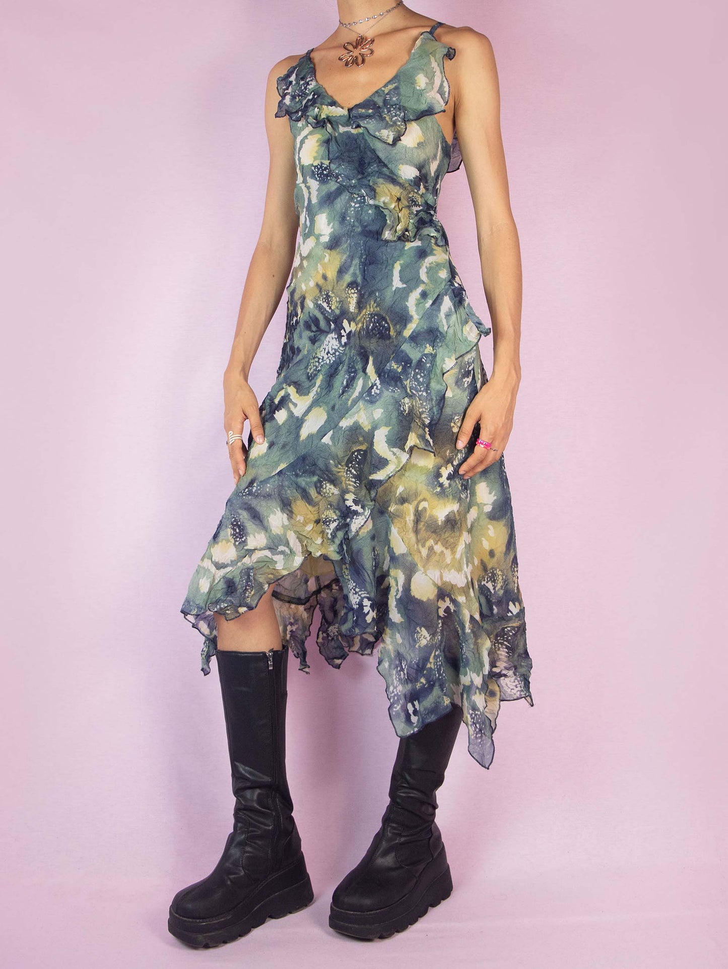 The Y2K Asymmetrical Ruffle Midi Dress is a vintage 2000s piece featuring an abstract print, delicate ruffle details along the neckline and hem, and an asymmetrical, flowy silhouette. Perfect for summer parties, evening outings, or a romantic day out.