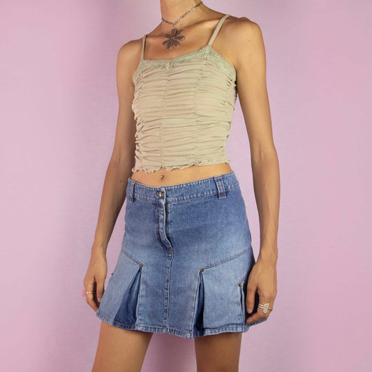 The Y2K Jean Pleated Mini Skirt is a vintage 2000s piece featuring a mid-rise fit and an A-line silhouette. Crafted from light-wash denim, it showcases pleated detailing along the hem and includes a front button and zipper closure. Perfect for casual wear and summer outings.