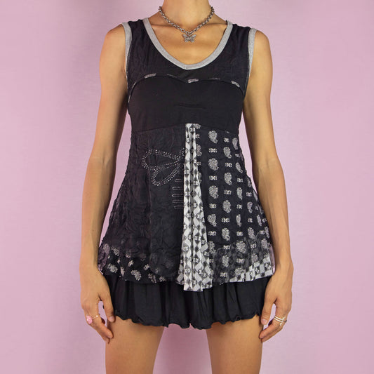 The Y2K Sleeveless Black Mesh Top is a vintage 2000s piece featuring an abstract print design, sheer mesh panels, and a flowy, layered silhouette. Perfect for a casual look.