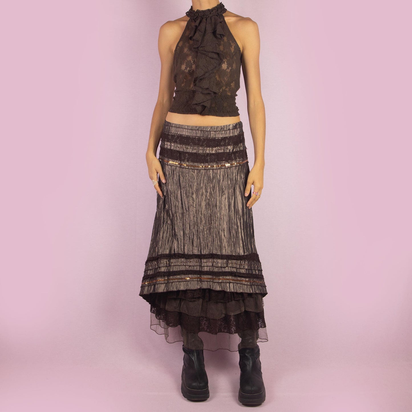 The Y2K Brown Layered Midi Skirt is a vintage 2000s piece featuring an earthy brown palette with a mix of crinkled fabric, lace, and mesh layers. The mid-waisted design and asymmetrical hemline create a flowy, bohemian silhouette, with a side zipper