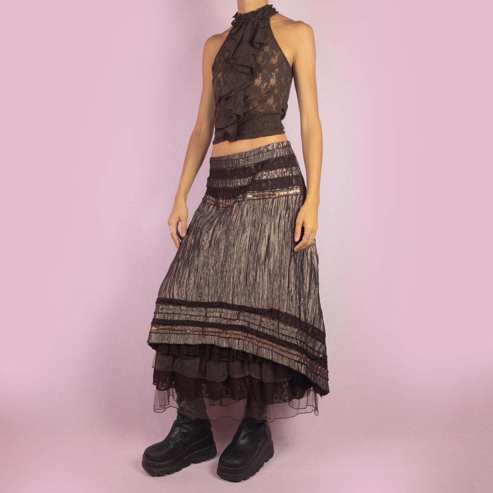 The Y2K Brown Layered Midi Skirt is a vintage 2000s piece featuring an earthy brown palette with a mix of crinkled fabric, lace, and mesh layers. The mid-waisted design and asymmetrical hemline create a flowy, bohemian silhouette, with a side zipper