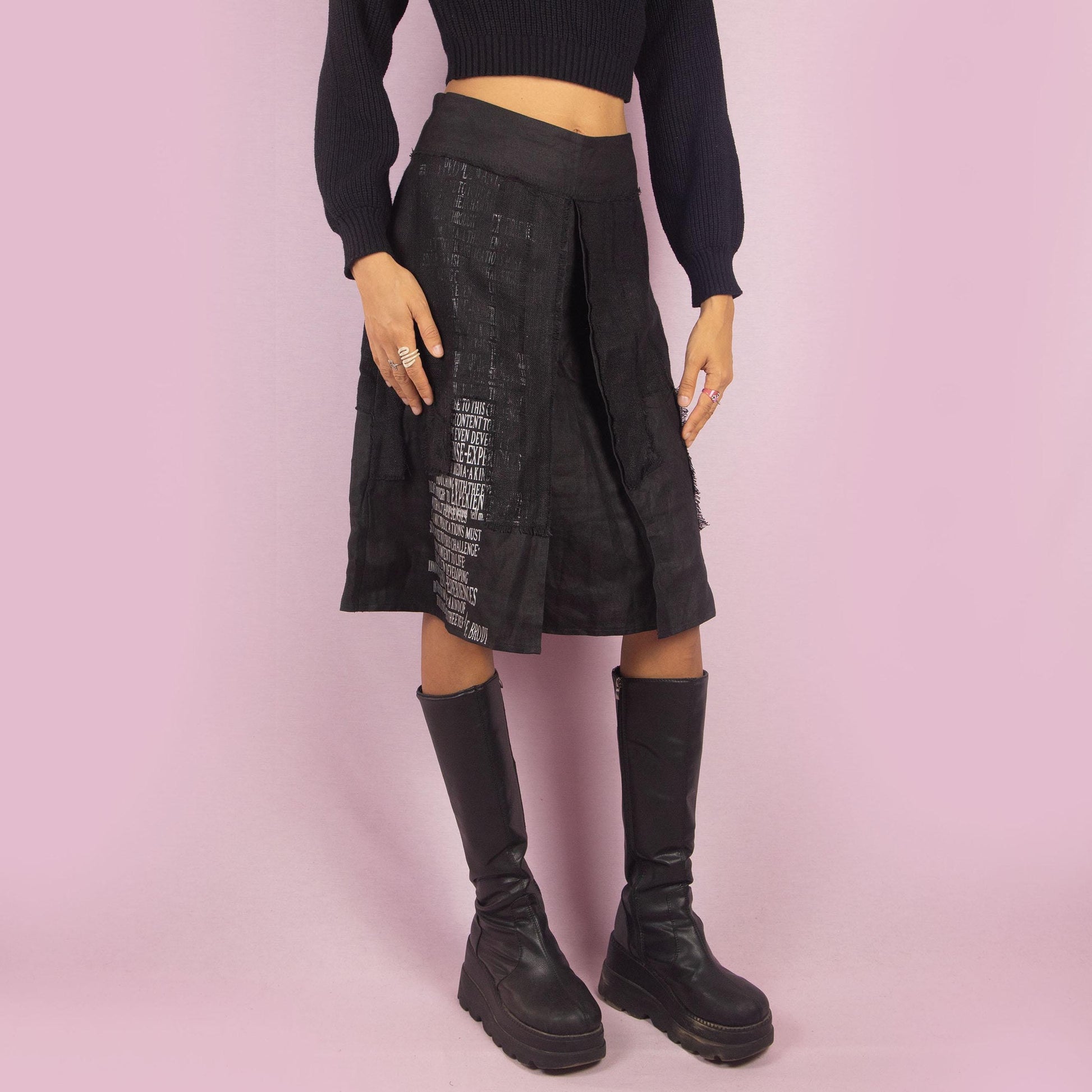 The Y2K Layered Black Midi Skirt features a unique design with contrasting text panels and raw hem details for an edgy and contemporary look. Its structured fit, midi length, low-rise waist, and back zipper closure make it perfect for casual looks.