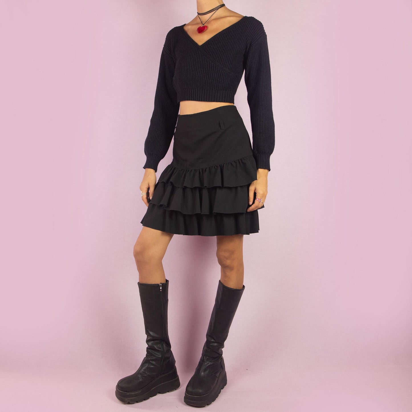 The Y2K Ruffle Black Mini Skirt is a vintage 2000s piece featuring playful tiered ruffles and a side zipper closure. Its mini length and flattering fit make it perfect for casual outings and evening events.