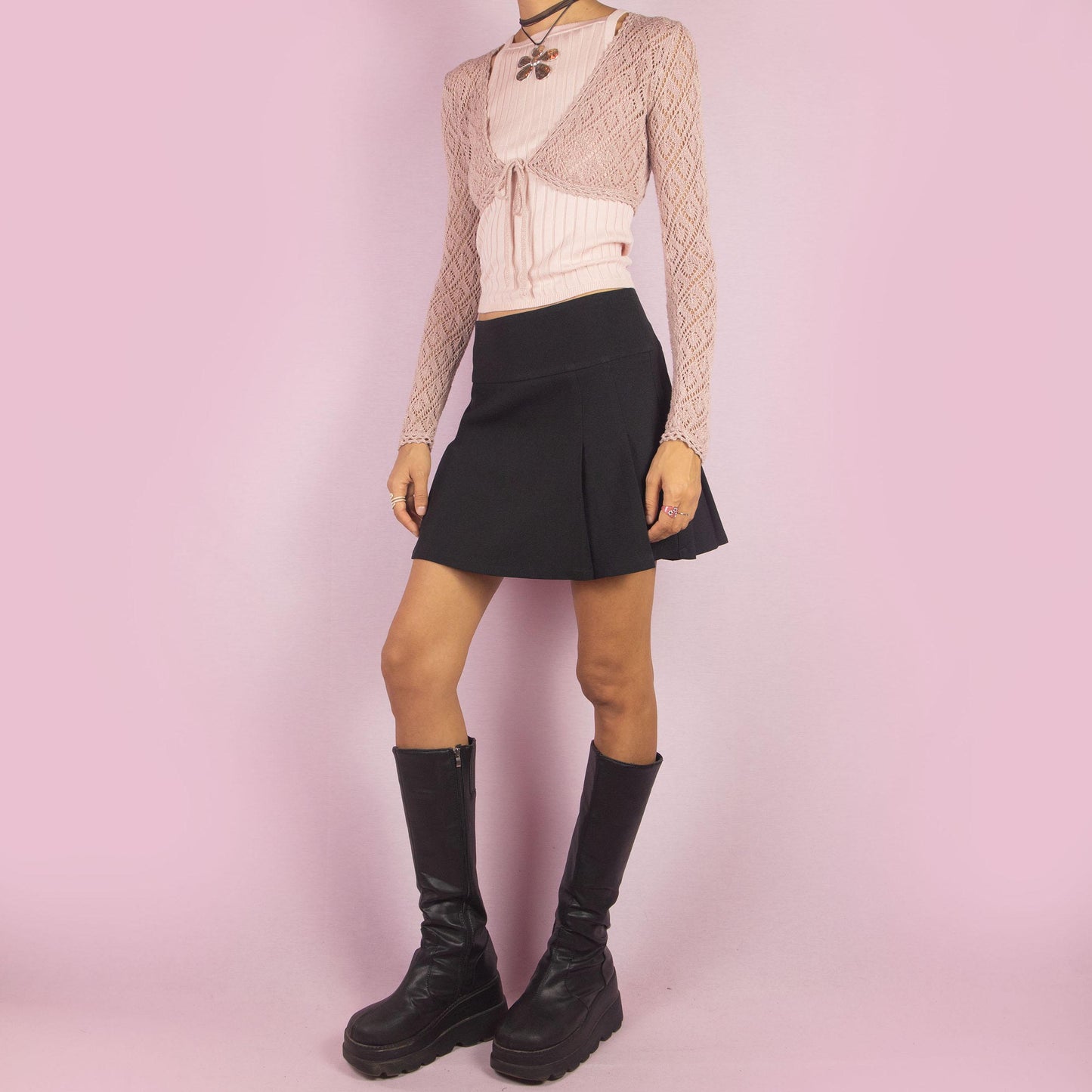 The Y2K Black Pleated Mini Skirt is a vintage 2000s piece featuring clean pleats, a flattering low-rise fit, and a back zipper closure, this mini skirt is a versatile piece, ideal for both casual and semi-formal outfits.