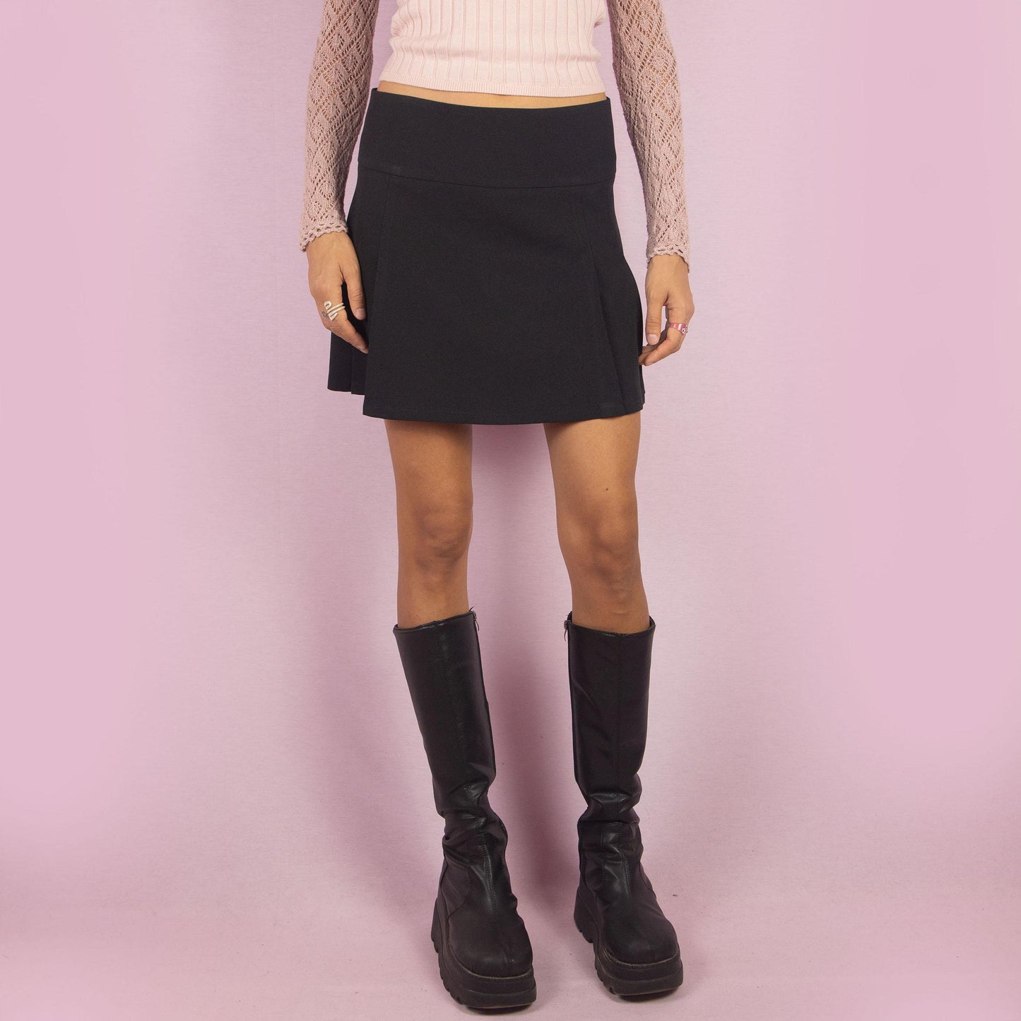 The Y2K Black Pleated Mini Skirt is a vintage 2000s piece featuring clean pleats, a flattering low-rise fit, and a back zipper closure, this mini skirt is a versatile piece, ideal for both casual and semi-formal outfits.