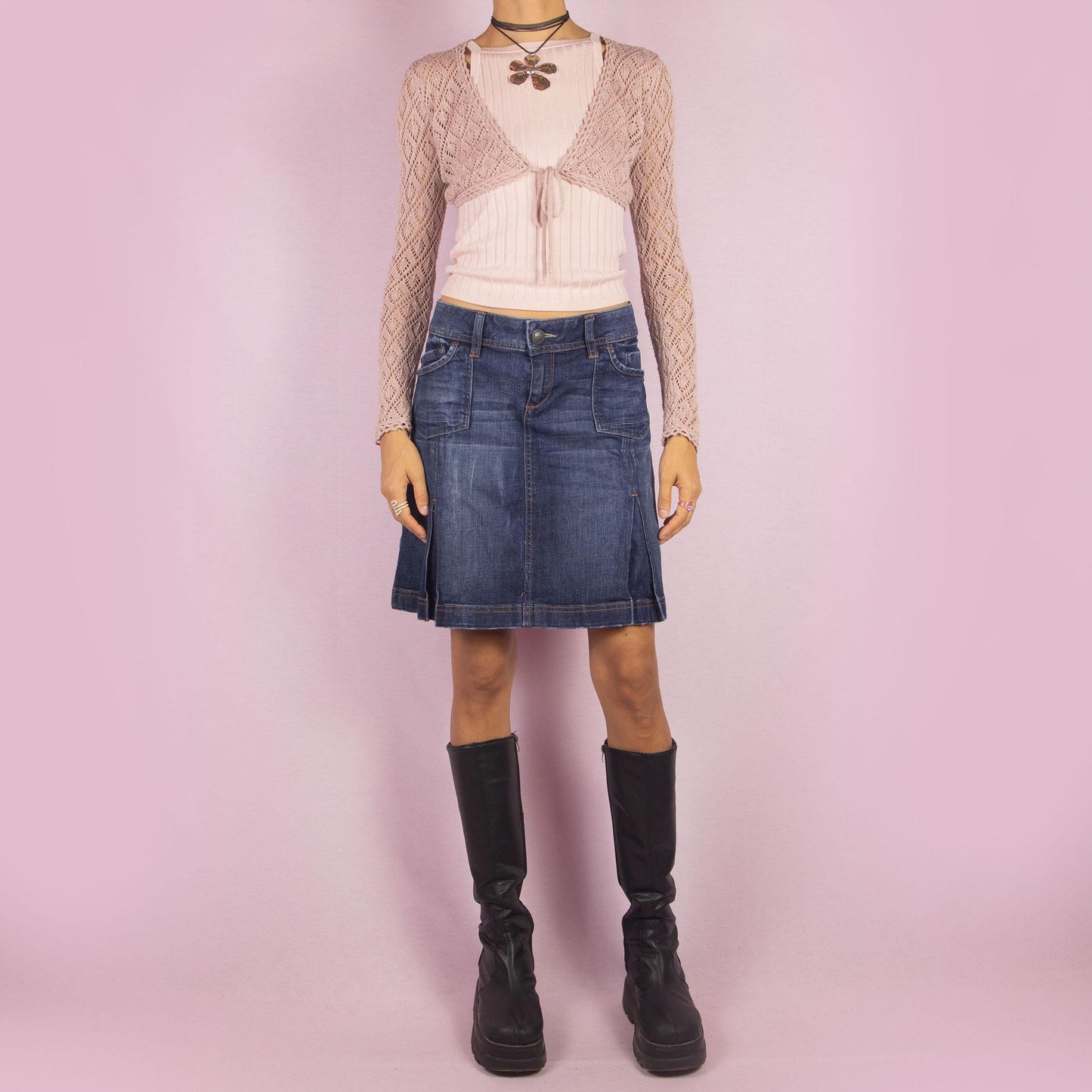 The Y2K Denim Pleated Skirt is a vintage 2000s piece featuring a structured A-line design with stitched pleats, pockets, a button-and-zipper front closure and stretchy fabric. Ideal for casual and chic everyday outfits.