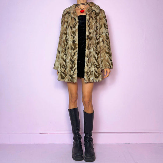 The Vintage 90s Chevron Faux Fur Coat is a cozy statement piece. Crafted with brown and beige soft faux fur, it features a pullover front closure and pockets. The bold pattern and relaxed fit make it ideal for stylish winter evening parties.