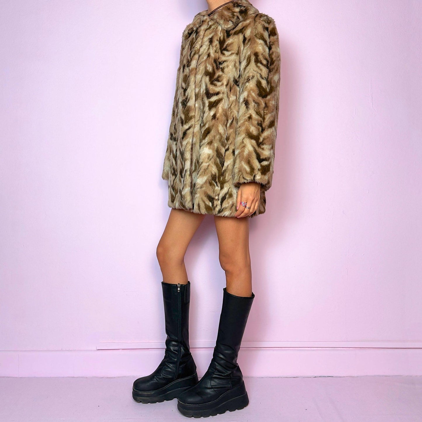 The Vintage 90s Chevron Faux Fur Coat is a cozy statement piece. Crafted with brown and beige soft faux fur, it features a pullover front closure and pockets. The bold pattern and relaxed fit make it ideal for stylish winter evening parties.