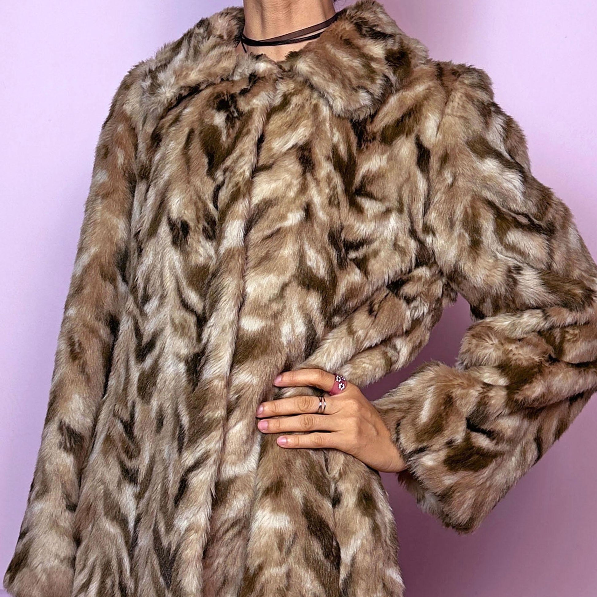 The Vintage 90s Chevron Faux Fur Coat is a cozy statement piece. Crafted with brown and beige soft faux fur, it features a pullover front closure and pockets. The bold pattern and relaxed fit make it ideal for stylish winter evening parties.