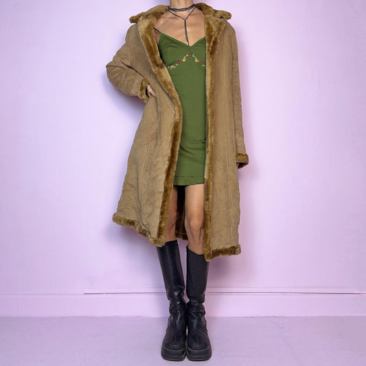 The Y2K Faux Suede Maxi Coat is a vintage 2000s cozy piece featuring a classic camel-tone faux suede exterior accented with plush faux fur trim along the collar, cuffs, and hem. This longline coat includes button-front closures and a tailored fit