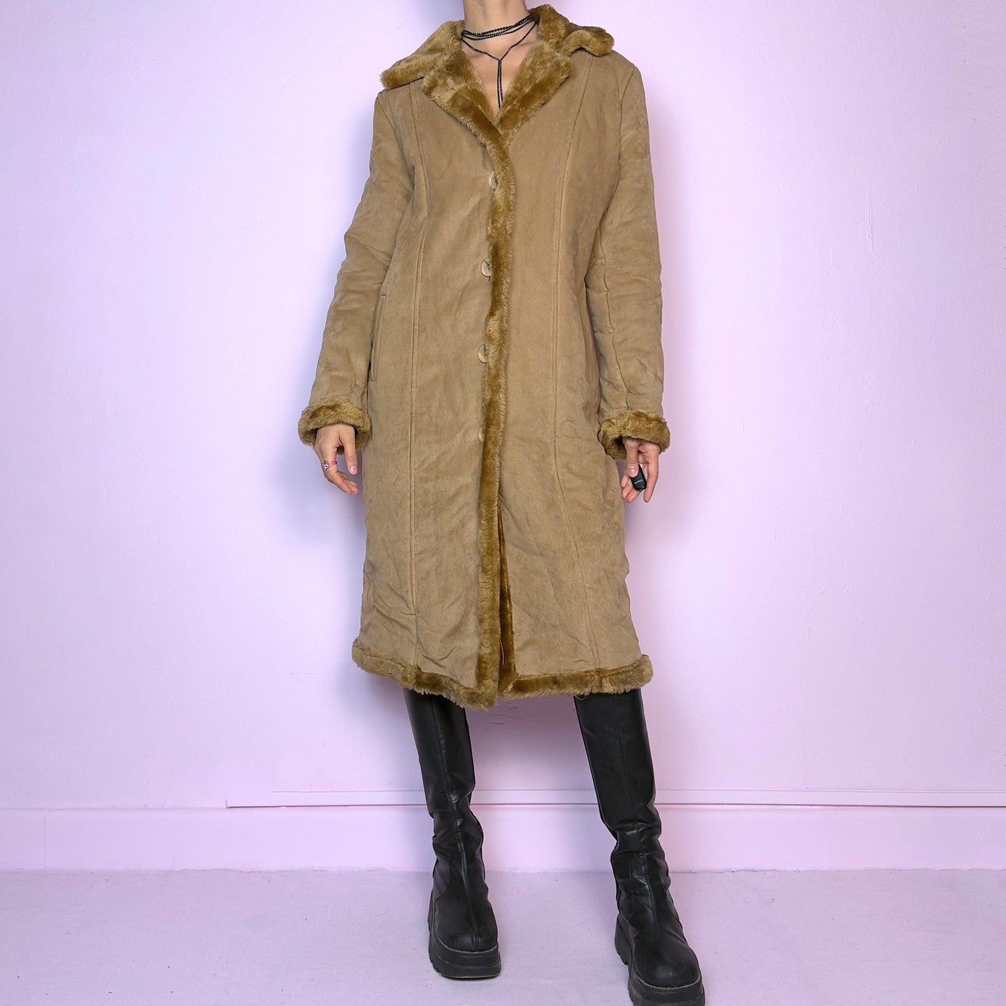 The Y2K Faux Suede Maxi Coat is a vintage 2000s cozy piece featuring a classic camel-tone faux suede exterior accented with plush faux fur trim along the collar, cuffs, and hem. This longline coat includes button-front closures and a tailored fit