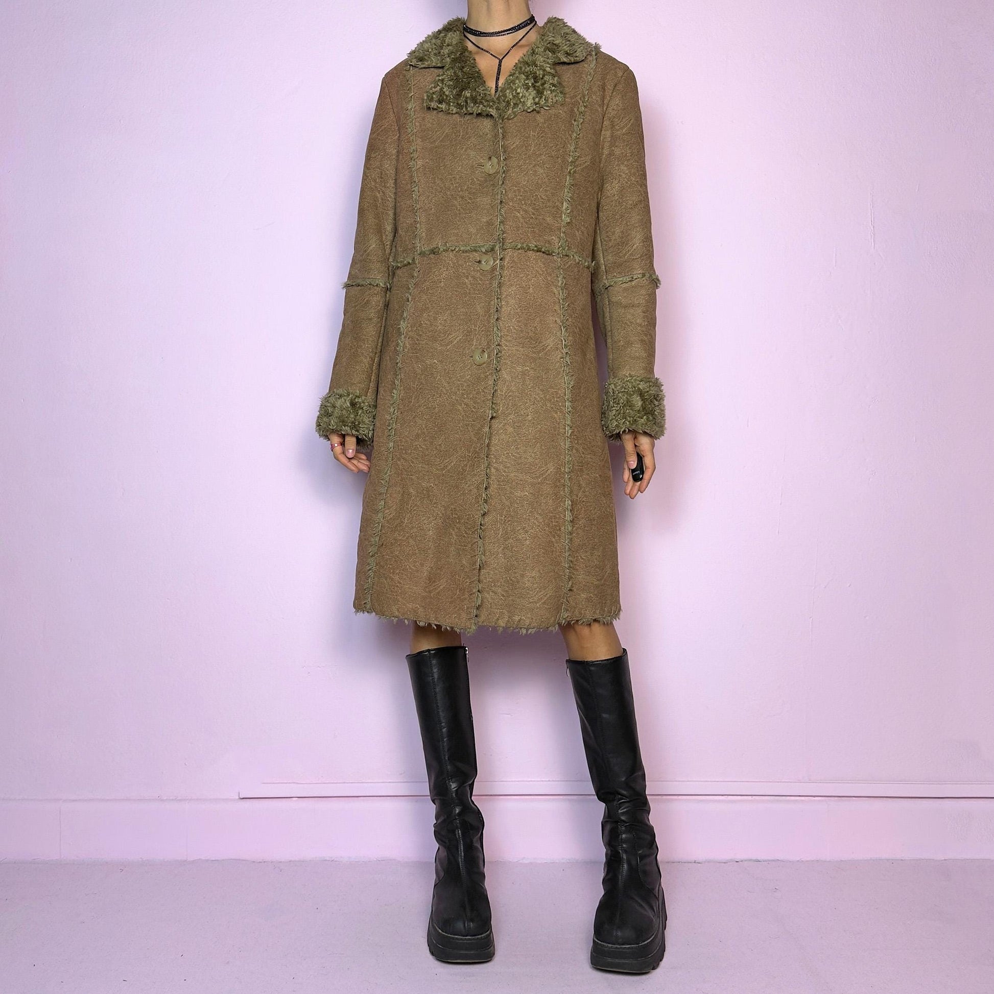 The Y2K Faux Fur Suede Long Coat is a vintage 2000s cozy piece featuring a soft brown faux suede exterior and faux shearling trim along the collar, cuffs, and seams. Its structured silhouette features button-front closure and pockets