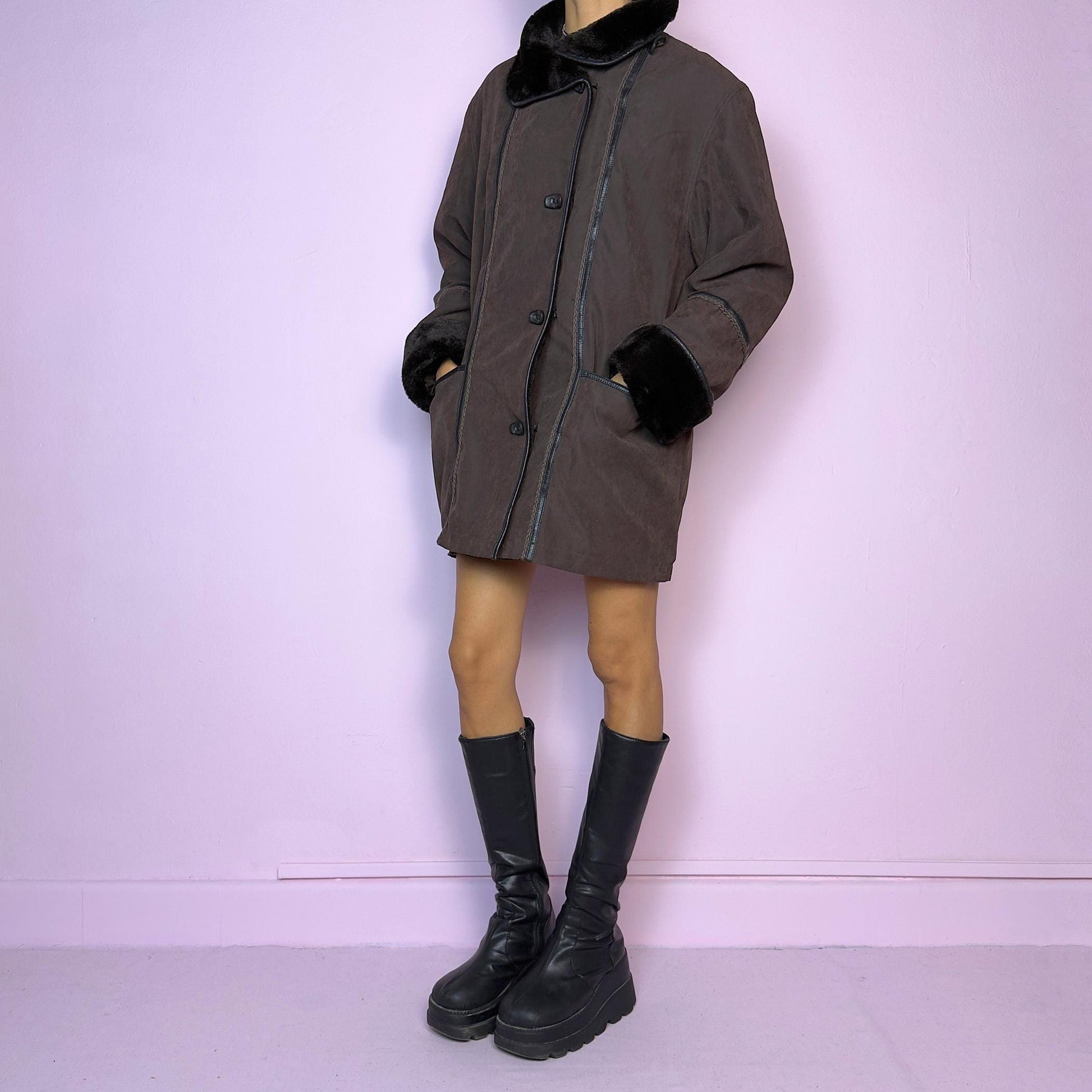 The Vintage 90s Brown Faux Fur Collar Coat features a deep brown hue with faux fur trim along the collar and cuffs and pockets. Its relaxed fit, toggle closures, and cozy design make it perfect for chilly winter outings or casual looks.