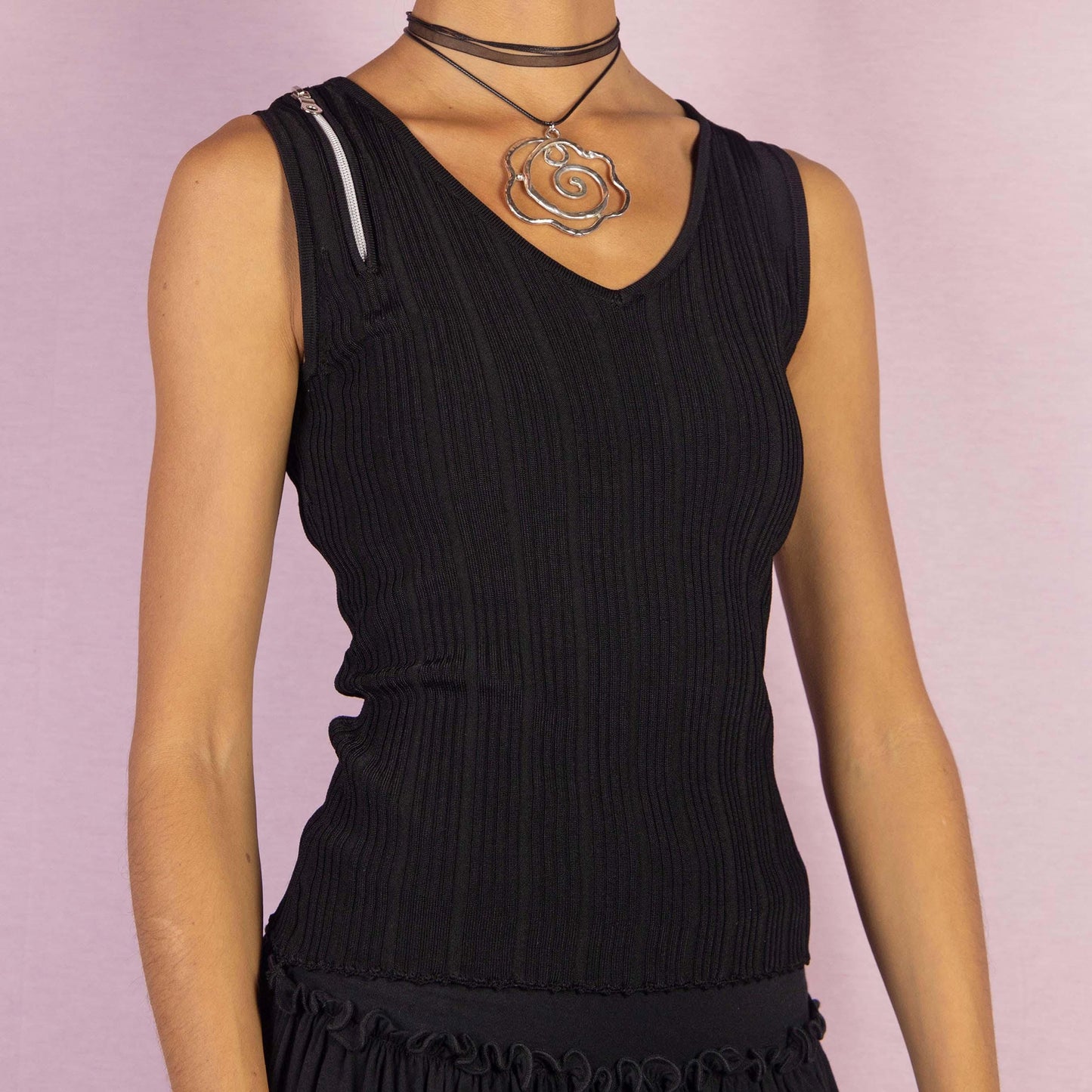 The Y2K Black Sleeveless Ribbed Top is a vintage 2000s essential, featuring a sleek ribbed texture, a flattering V-neckline, a minimalistic design and a zipper detail on the shoulder. Perfect for casual-chic looks.