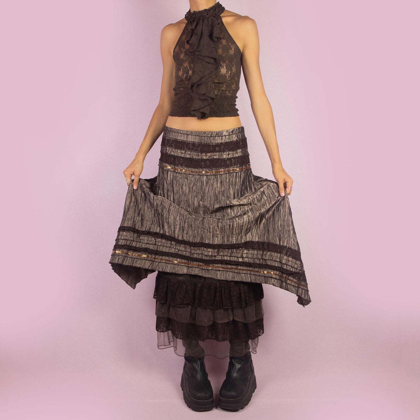 The Y2K Brown Layered Midi Skirt is a vintage 2000s piece featuring an earthy brown palette with a mix of crinkled fabric, lace, and mesh layers. The mid-waisted design and asymmetrical hemline create a flowy, bohemian silhouette, with a side zipper