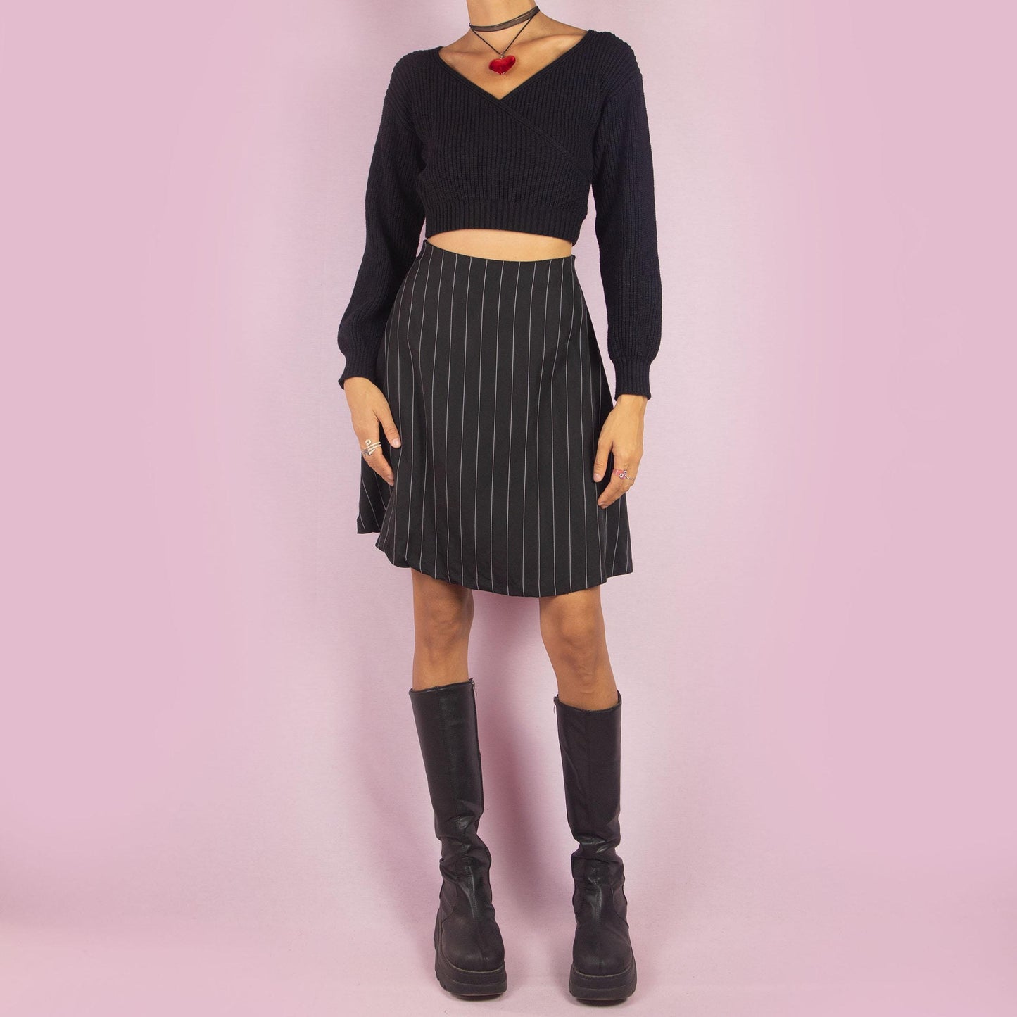 The Y2K Black Pinstripe Mini Skirt is a vintage 2000s piece featuring a chic pinstripe pattern, a flattering A-line silhouette, and a mini length. It also includes a side zipper closure. Perfect for both office looks and casual outings.