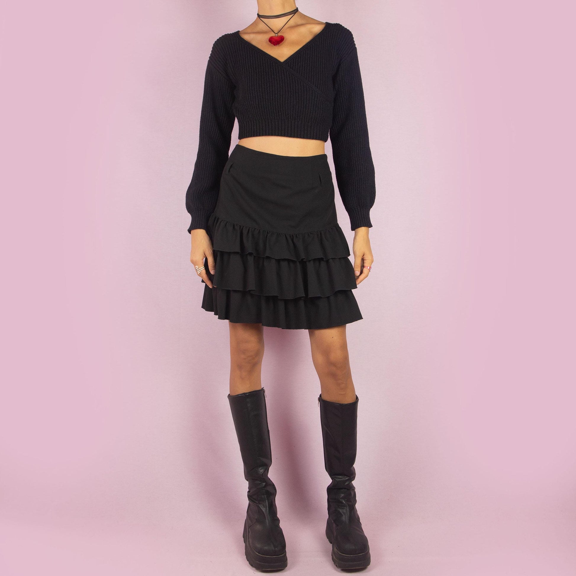 The Y2K Ruffle Black Mini Skirt is a vintage 2000s piece featuring playful tiered ruffles and a side zipper closure. Its mini length and flattering fit make it perfect for casual outings and evening events.