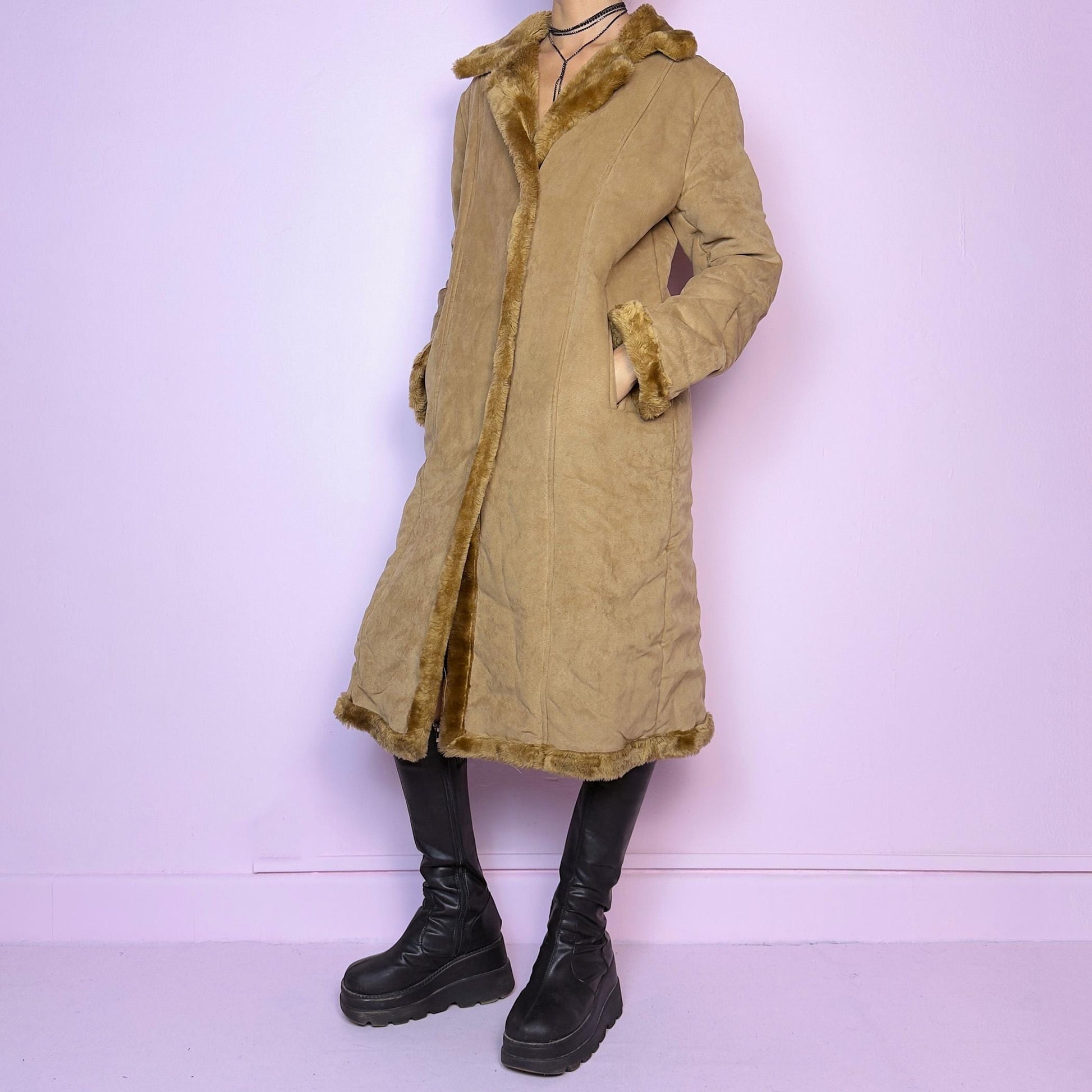 The Y2K Faux Suede Maxi Coat is a vintage 2000s cozy piece featuring a classic camel-tone faux suede exterior accented with plush faux fur trim along the collar, cuffs, and hem. This longline coat includes button-front closures and a tailored fit