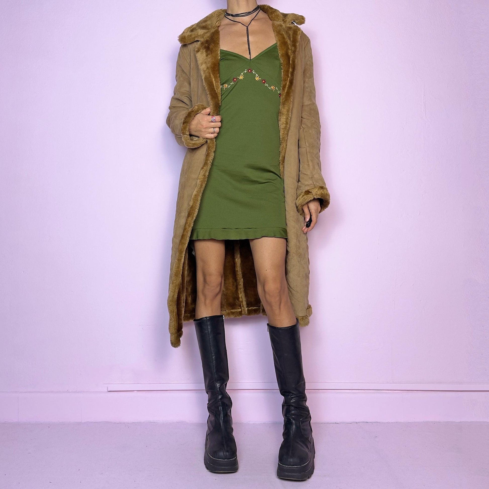 The Y2K Faux Suede Maxi Coat is a vintage 2000s cozy piece featuring a classic camel-tone faux suede exterior accented with plush faux fur trim along the collar, cuffs, and hem. This longline coat includes button-front closures and a tailored fit