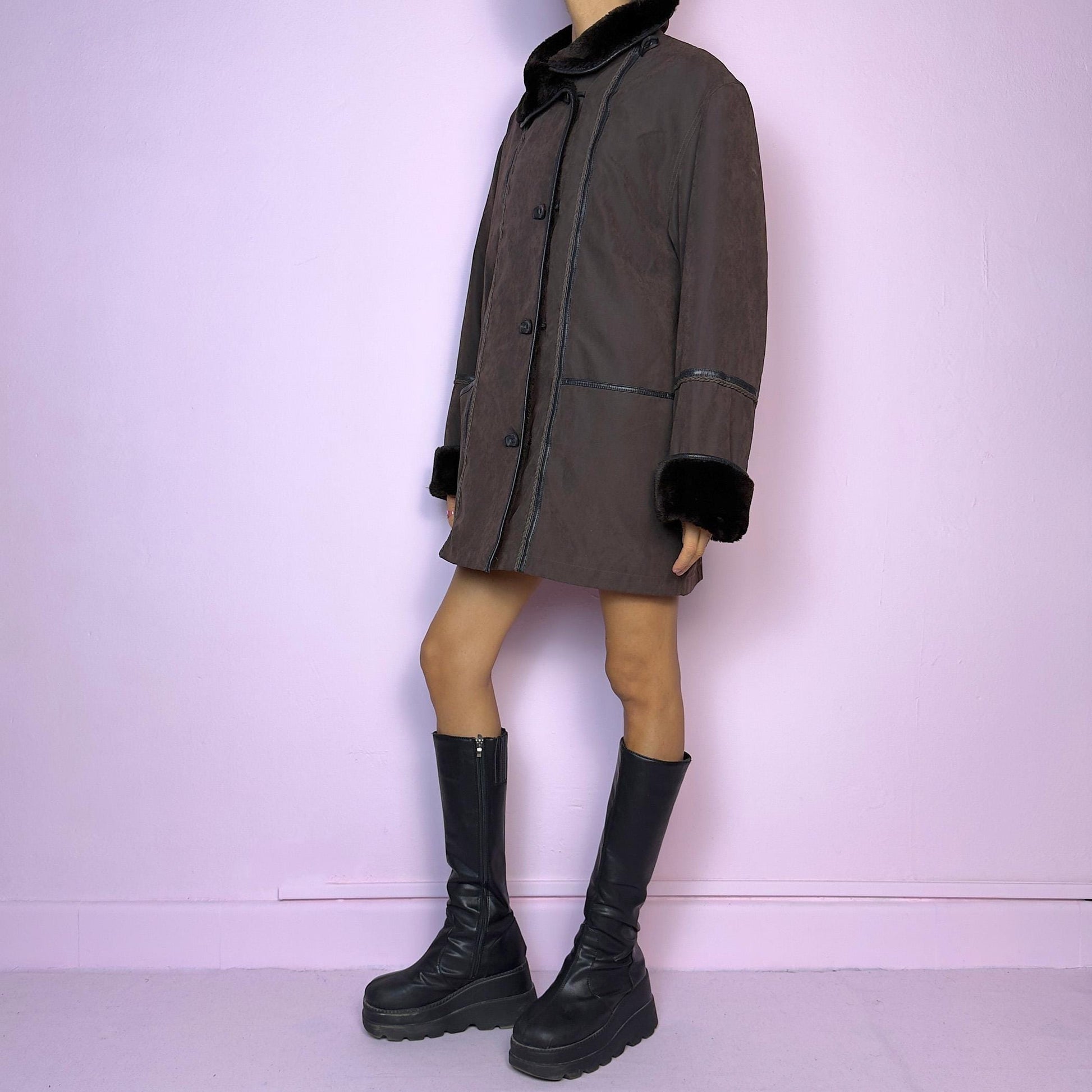 The Vintage 90s Brown Faux Fur Collar Coat features a deep brown hue with faux fur trim along the collar and cuffs and pockets. Its relaxed fit, toggle closures, and cozy design make it perfect for chilly winter outings or casual looks.