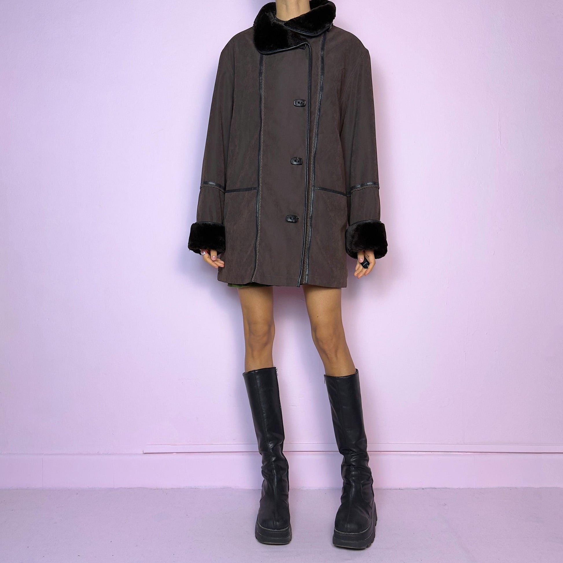 The Vintage 90s Brown Faux Fur Collar Coat features a deep brown hue with faux fur trim along the collar and cuffs and pockets. Its relaxed fit, toggle closures, and cozy design make it perfect for chilly winter outings or casual looks.