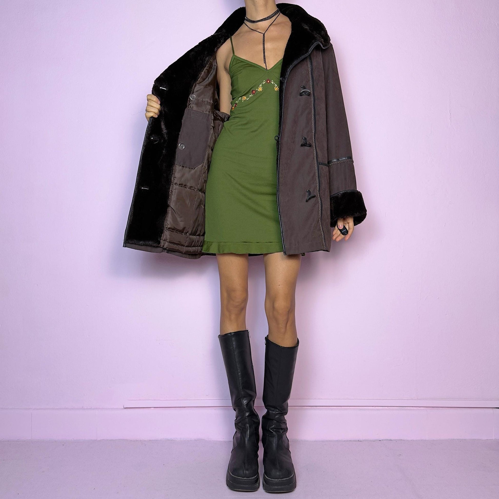 The Vintage 90s Brown Faux Fur Collar Coat features a deep brown hue with faux fur trim along the collar and cuffs and pockets. Its relaxed fit, toggle closures, and cozy design make it perfect for chilly winter outings or casual looks.